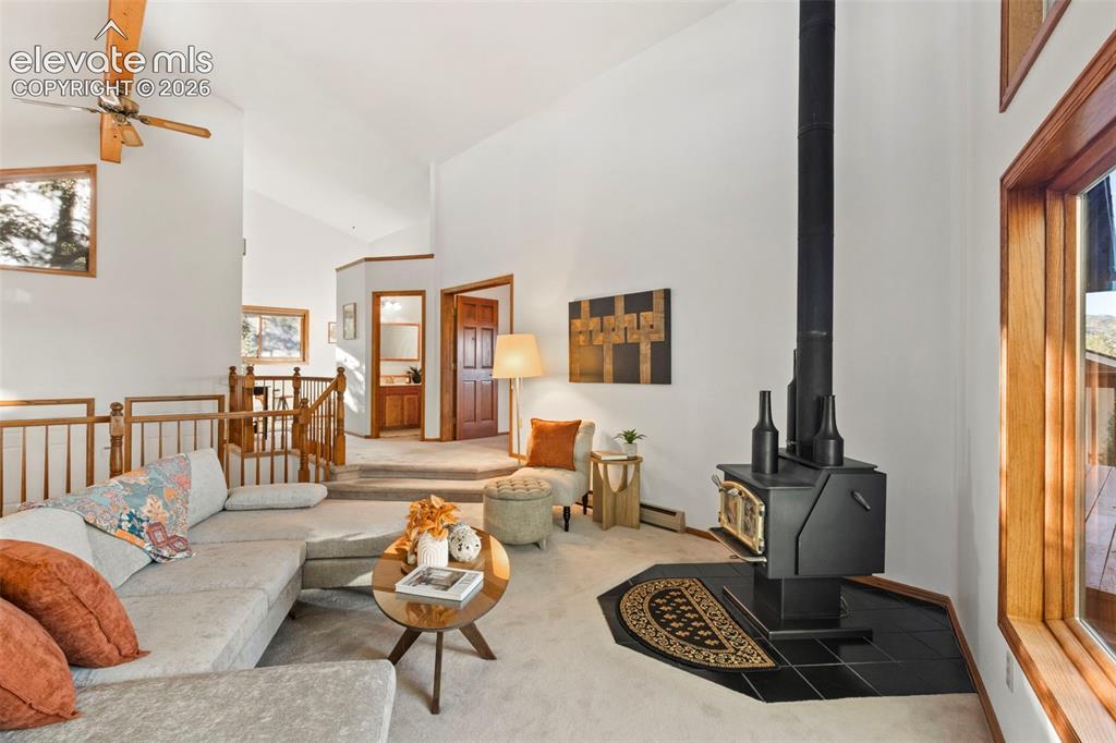 Image 8 of 47: Vaulted ceilings, free-standing wood-burning stove on a tile hearth, wood-c