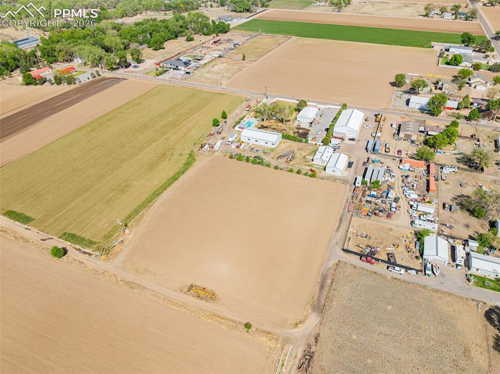 Image 14 of 20: Expansive aerial view showcasing agricultural fields and a cluster of light