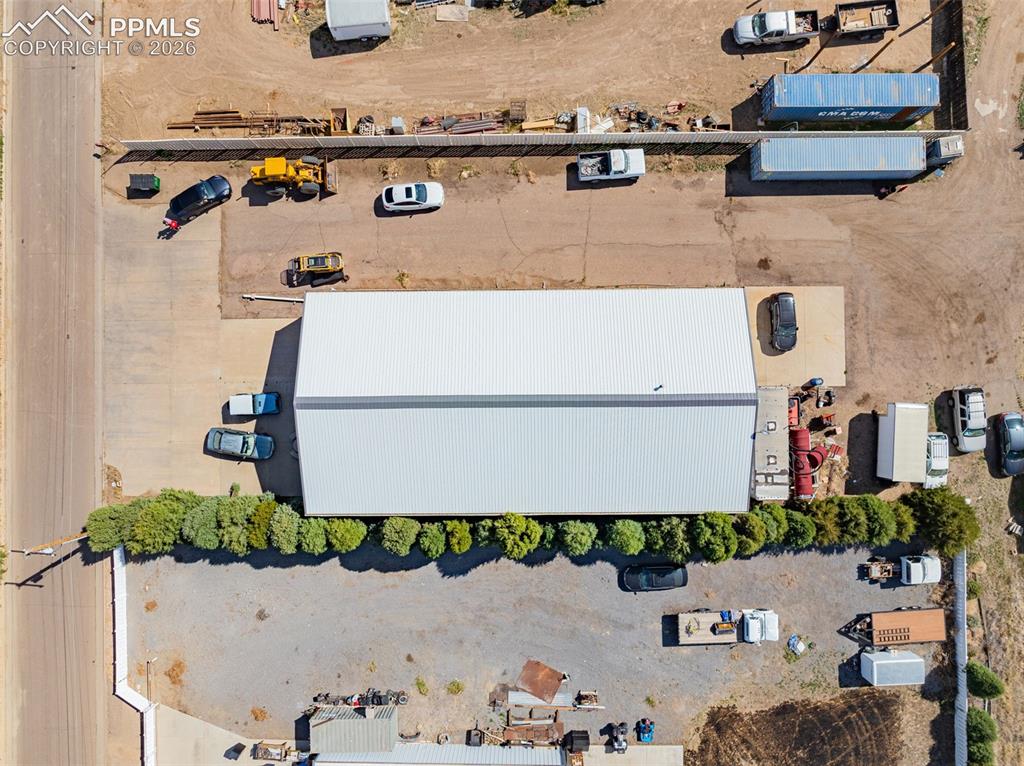 Image 5 of 20: Industrial property featuring a main building with a metal roof, extensive