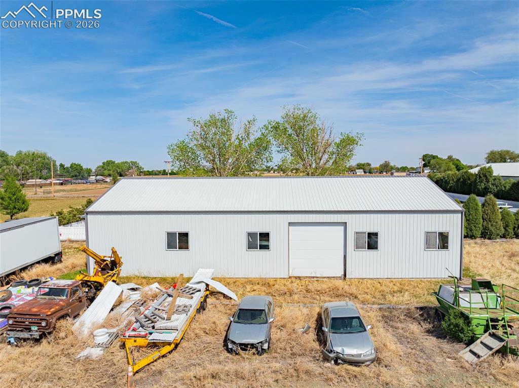 Image 7 of 20: Metal-sided industrial building featuring a white corrugated roof and white