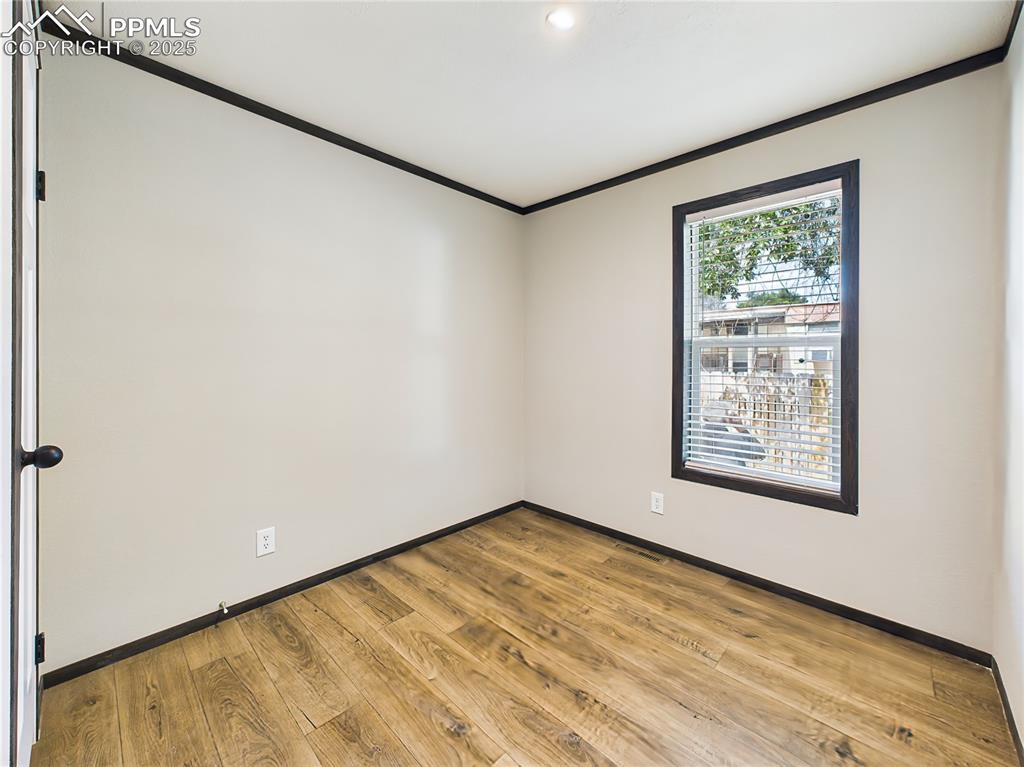 Image 28 of 39: Bedroom 2 – Comfortable secondary bedroom with a window view and rich floor