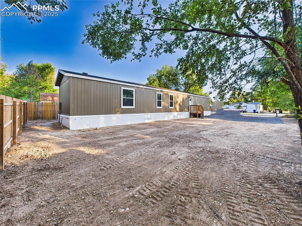 Image 35 of 39: Generous side yard with partial shade, offering flexibility for parking, ga