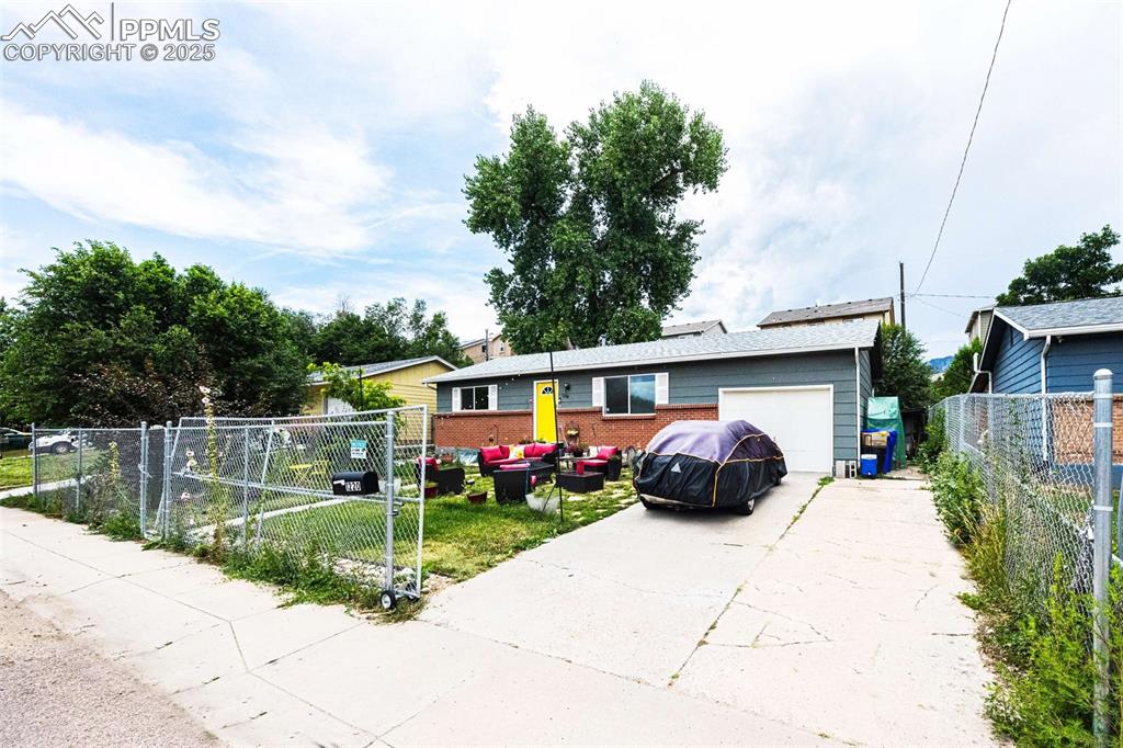 Image 2 of 21: Single story home with outdoor lounge area, driveway, and an attached garag