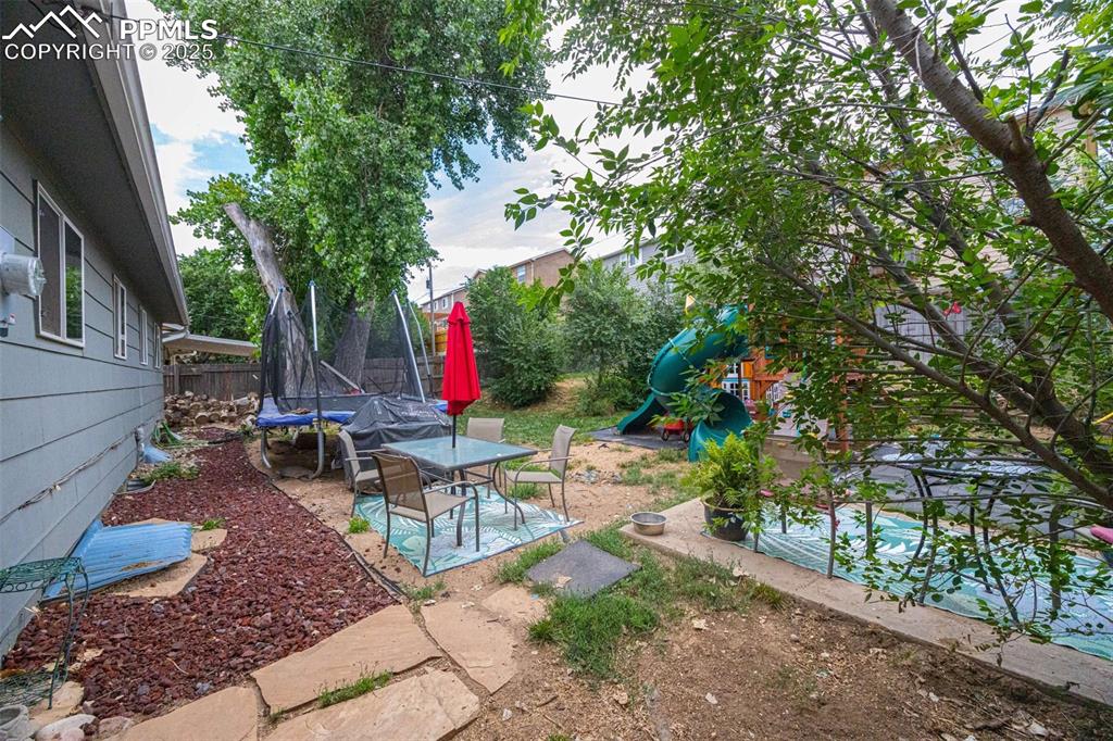 Image 20 of 21: View of yard featuring a trampoline and a patio