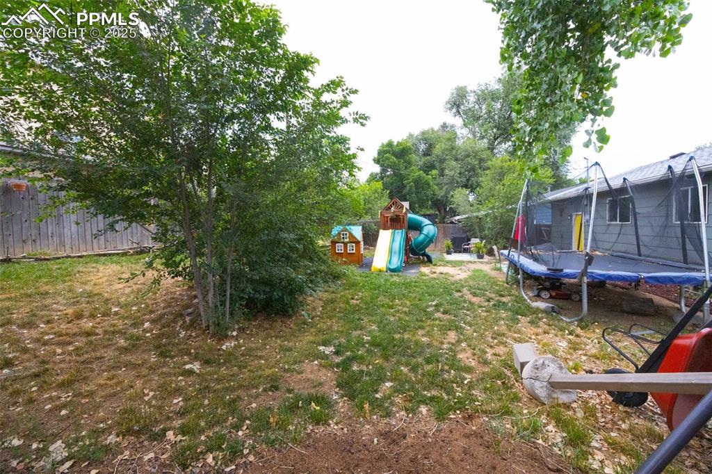 Image 21 of 21: View of yard featuring a trampoline and a playground
