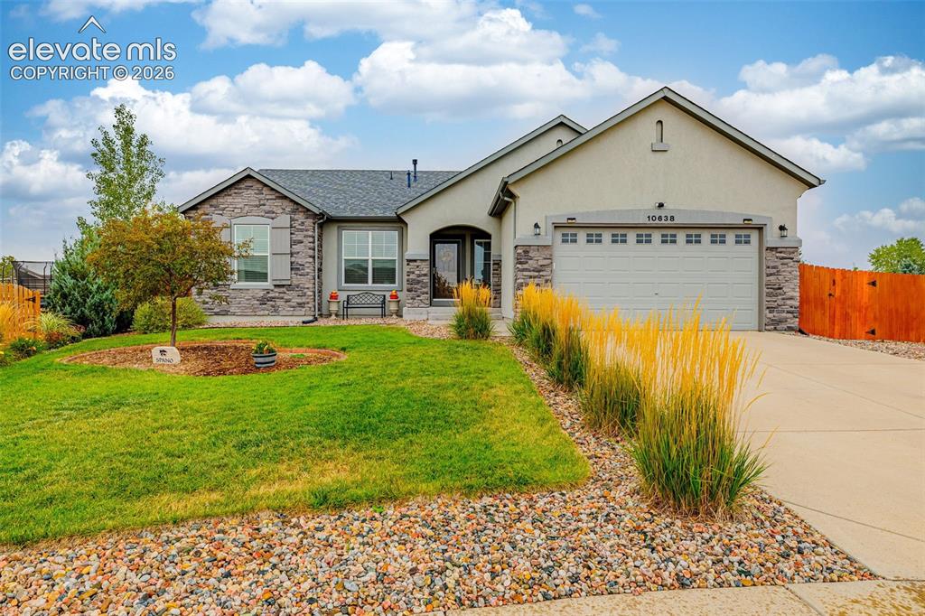 Caption: Single-story exterior featuring a combination stone and stucco facade, multi-gabled roofline, two-ca
