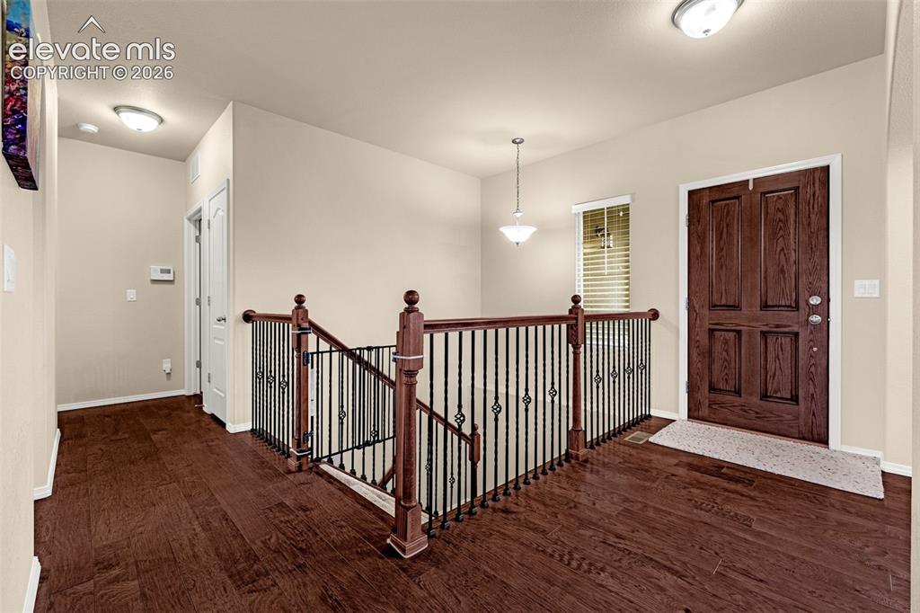 Image 15 of 49: Entryway featuring wood-finish flooring, a solid wood six-panel front door,