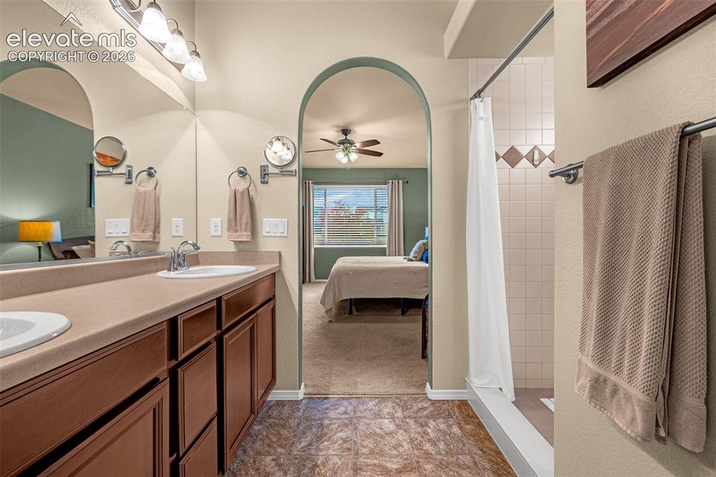Image 20 of 49: Bathroom featuring a double-sink vanity with a solid-surface countertop, ar