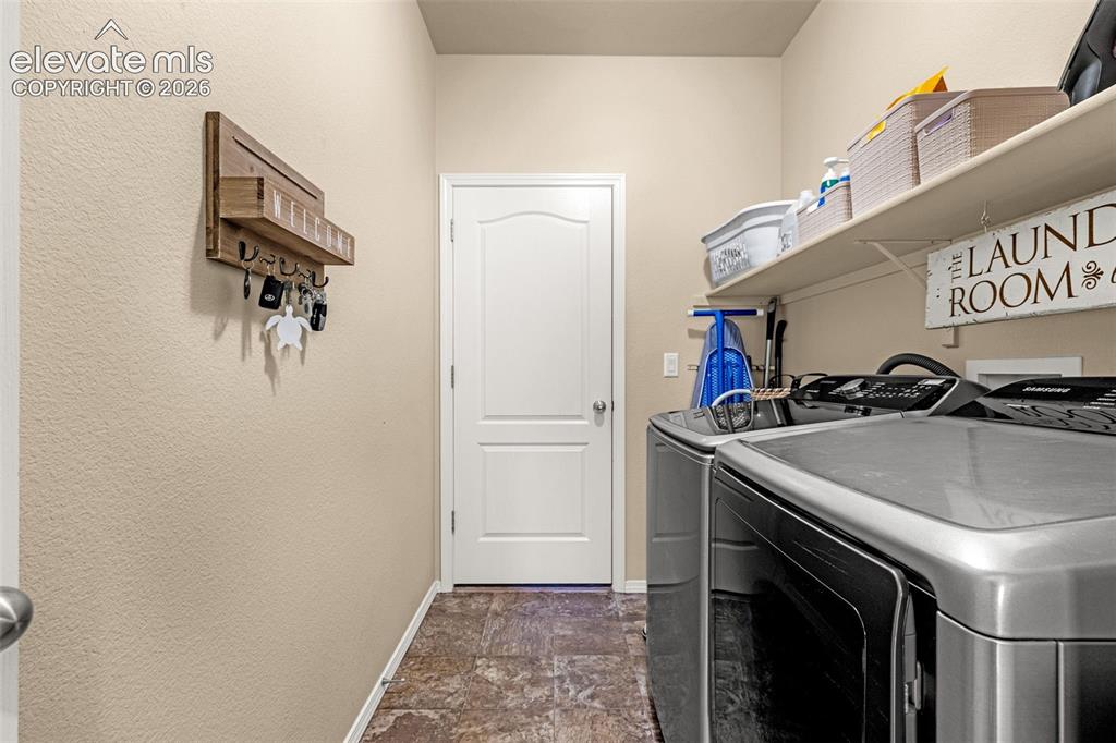 Image 23 of 49: Multi-purpose utility space featuring stone-style flooring, a solid core in