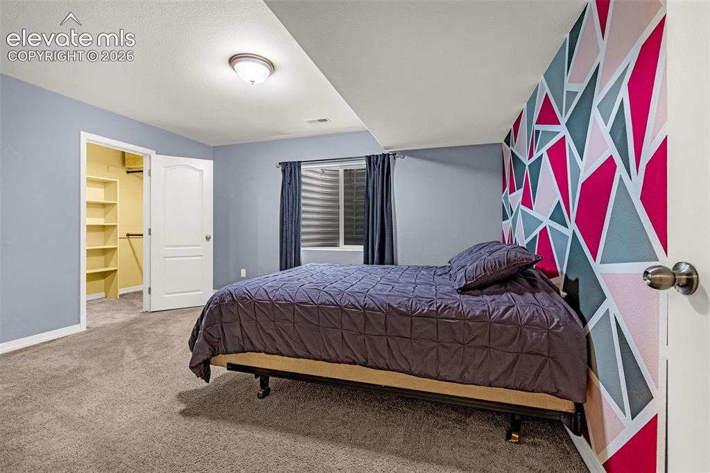 Image 34 of 49: Neutral wall tones, geometric accent wall, wall-to-wall carpeting, window w