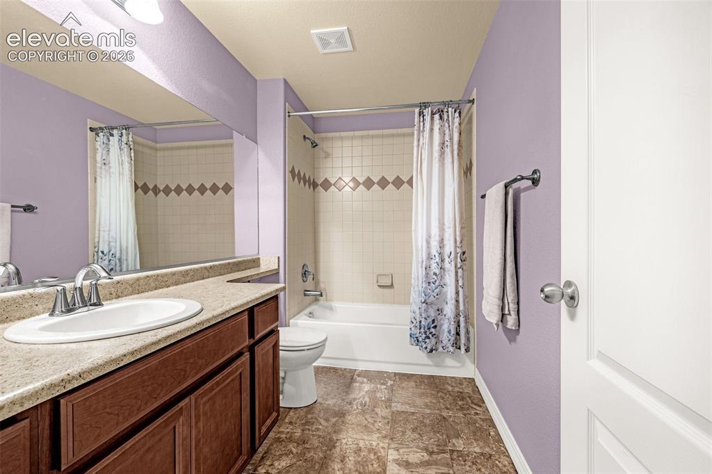 Image 35 of 49: Bathroom featuring a vanity with a light-toned solid surface countertop, an