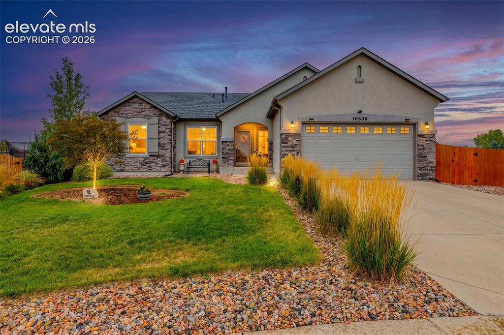 Image 37 of 49: Single-story residence featuring a stone and stucco facade, an attached thr