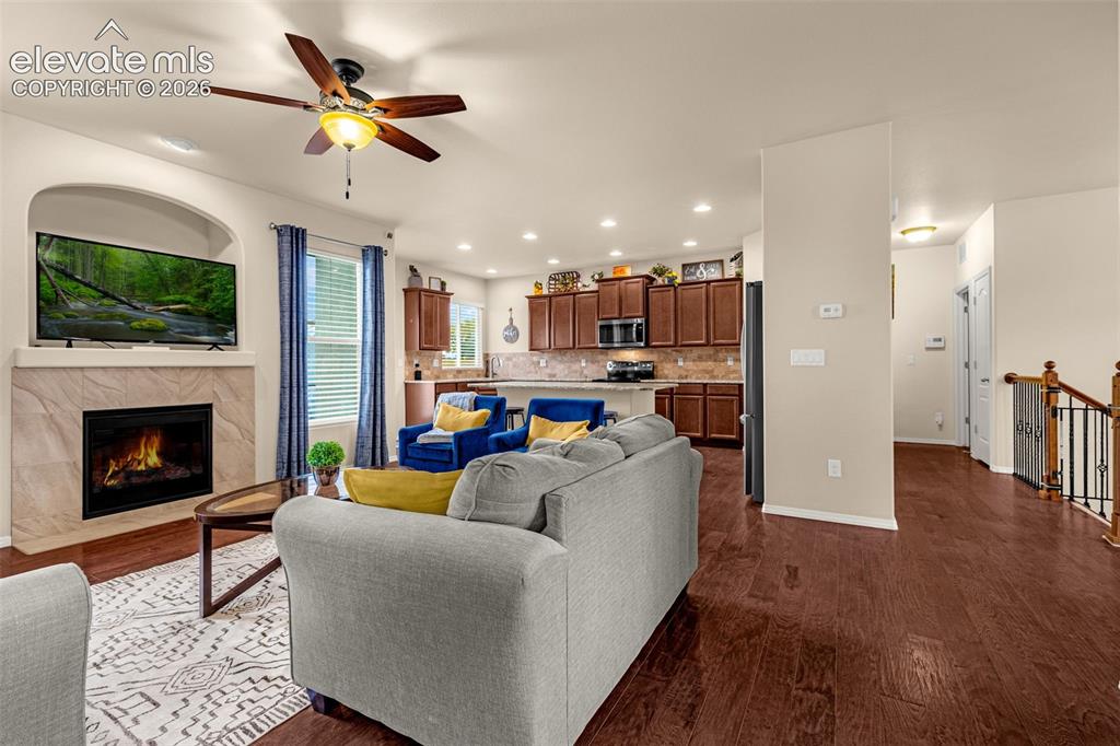 Image 4 of 49: Open-concept space featuring wood-finish flooring, a stone-surround firepla