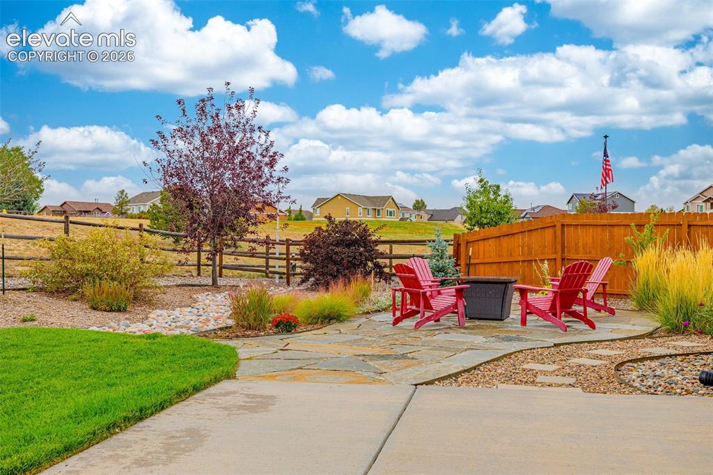 Image 40 of 49: Backyard featuring a flagstone patio, wood privacy fencing, a split-rail re