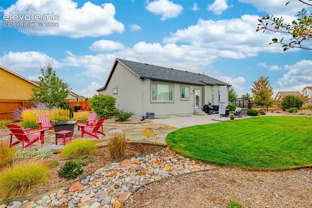 Image 41 of 49: Backyard featuring a concrete patio, irregular flagstone hardscaping, a riv