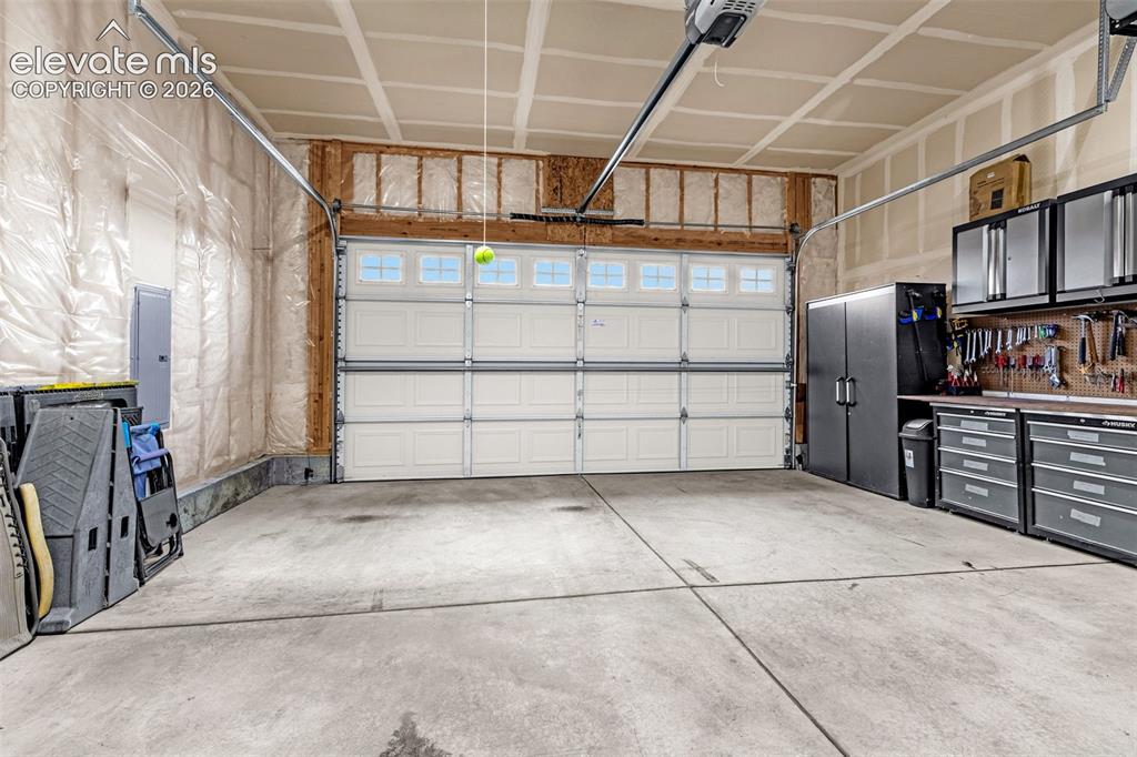 Image 48 of 49: Attached two-car garage featuring a sectional door with windows, concrete f