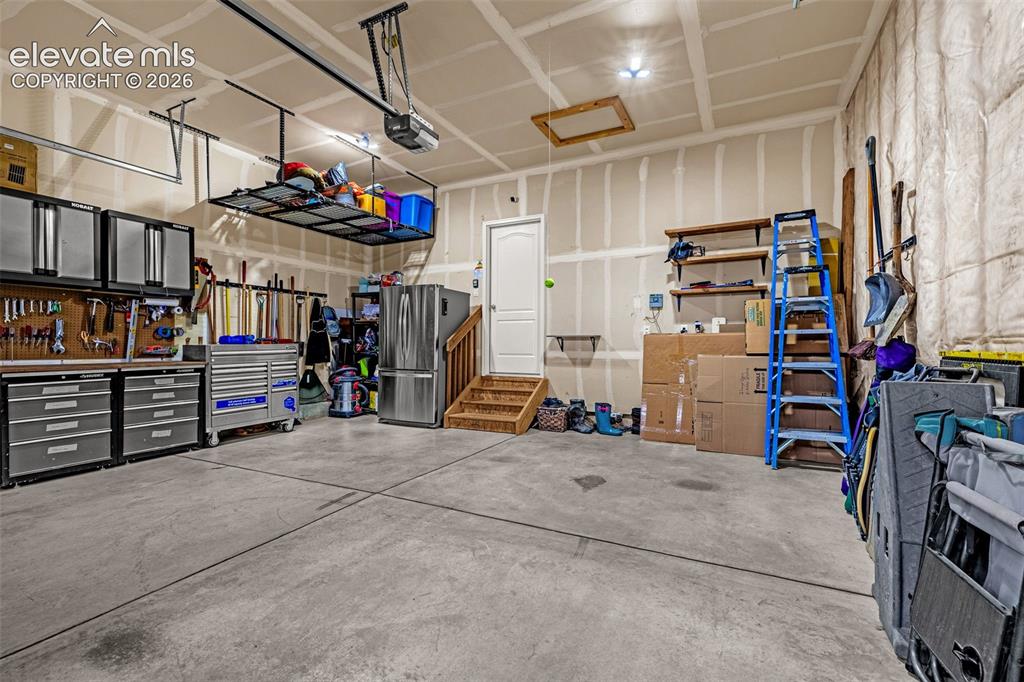 Image 49 of 49: Finished garage interior featuring concrete flooring, ceiling-mounted stora