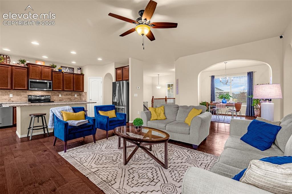 Image 6 of 49: Open-concept living space featuring wood-finish flooring, dark-stained wood