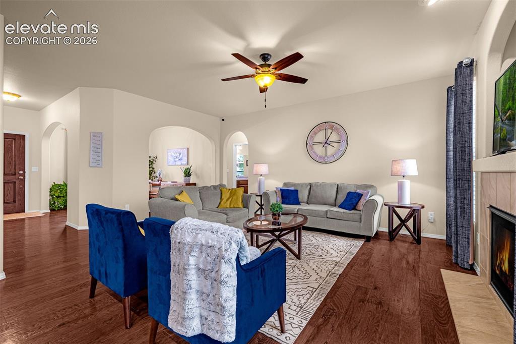 Image 9 of 49: Living area featuring wood-finish flooring, recessed archways, a ceiling fa