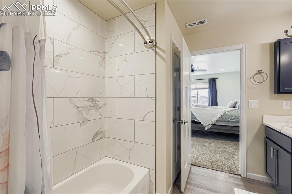 Image 15 of 23: Ensuite bathroom with shower / bath combo with shower curtain, vanity, and 