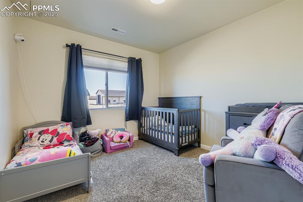 Image 17 of 23: Bedroom featuring carpet floors and a nursery area