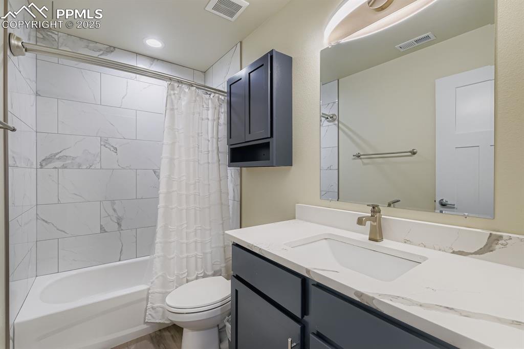 Image 18 of 23: Full bathroom featuring shower / bathtub combination with curtain and vanit