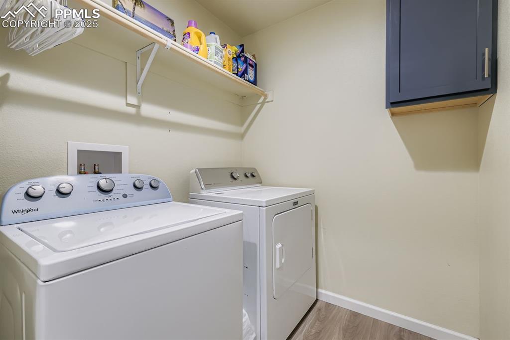 Image 19 of 23: Laundry room with light wood-type flooring, separate washer and dryer, and 