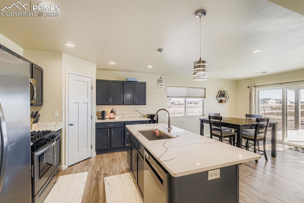 Image 8 of 23: Kitchen featuring pendant lighting, appliances with stainless steel finishe