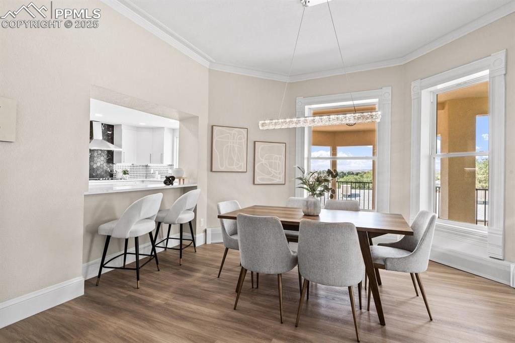 Image 12 of 50: Dining area featuring ornamental molding, wood finished floors, and baseboa