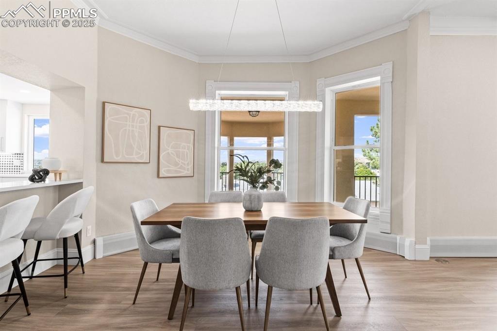 Image 13 of 50: Dining room with wood finished floors, crown molding, and baseboards