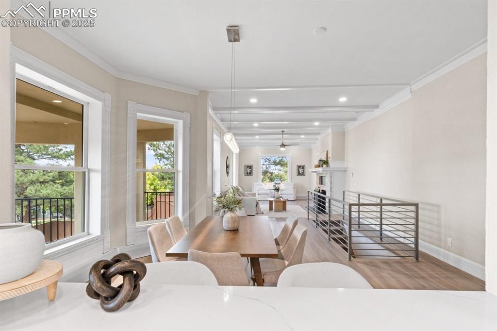 Image 15 of 50: Dining space with ornamental molding, wood finished floors, baseboards, and