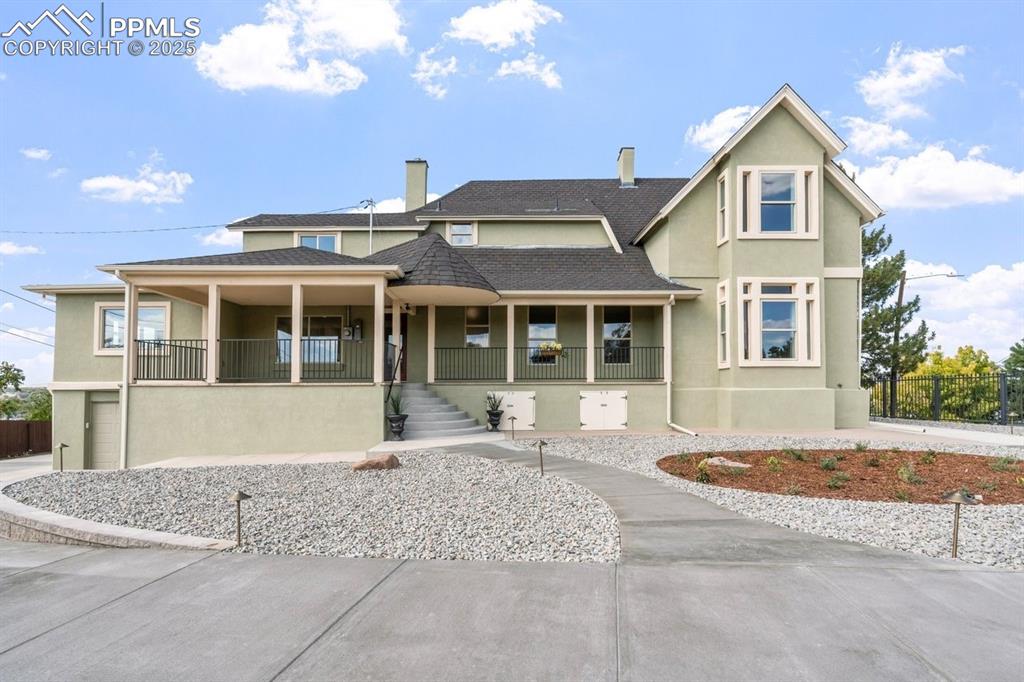 Image 2 of 50: View of front facade with covered porch, stucco siding, roof with shingles,