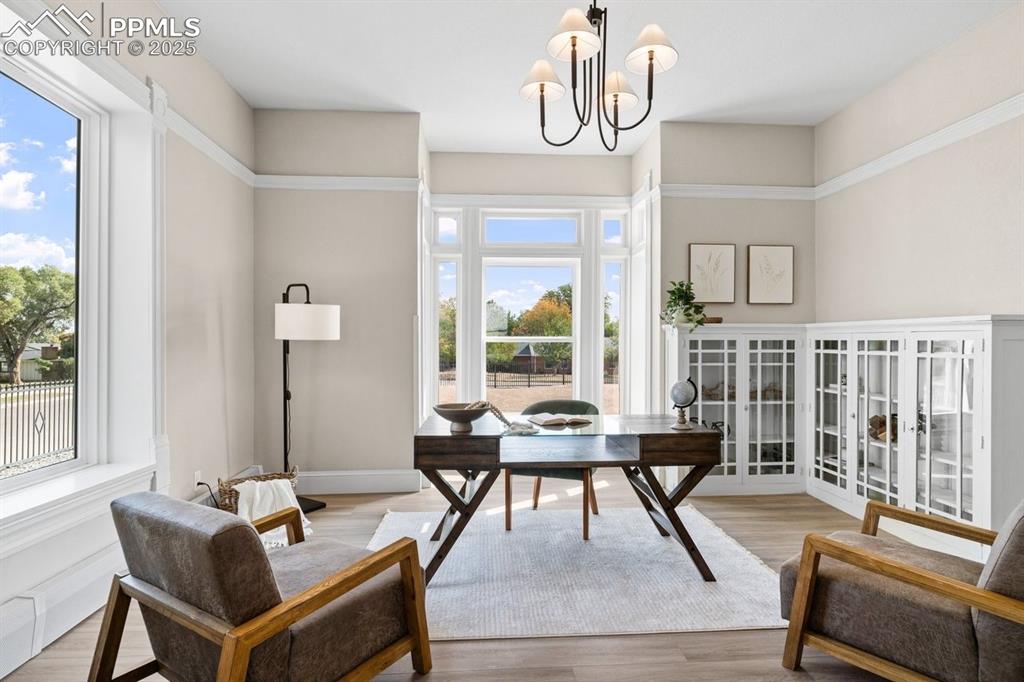 Image 20 of 50: Home office with a chandelier, light wood-style flooring, and french doors