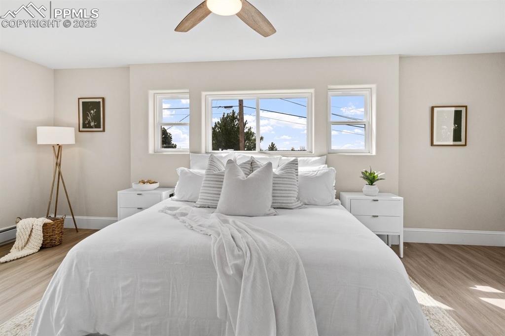 Image 27 of 50: Bedroom featuring light wood-style flooring, baseboards, multiple windows,
