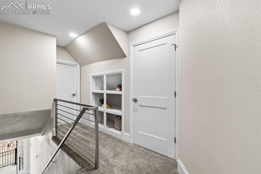 Image 29 of 50: Corridor featuring carpet flooring, an upstairs landing, a textured wall, r