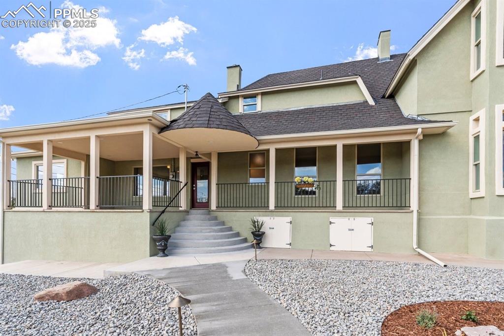 Image 3 of 50: View of front of property with a chimney, covered porch, stucco siding, and