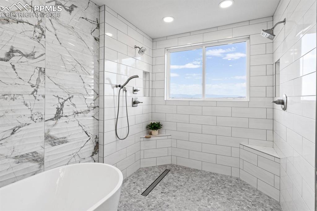 Image 35 of 50: Full bathroom with a freestanding tub, tiled shower, and recessed lighting