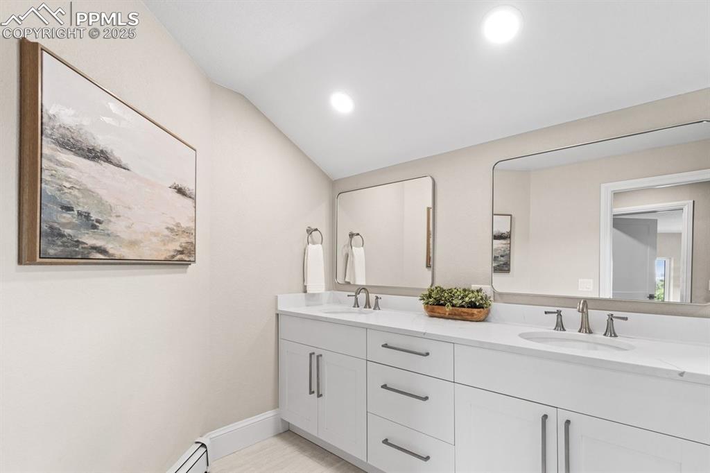 Image 42 of 50: Full bathroom featuring double vanity, lofted ceiling, recessed lighting, a