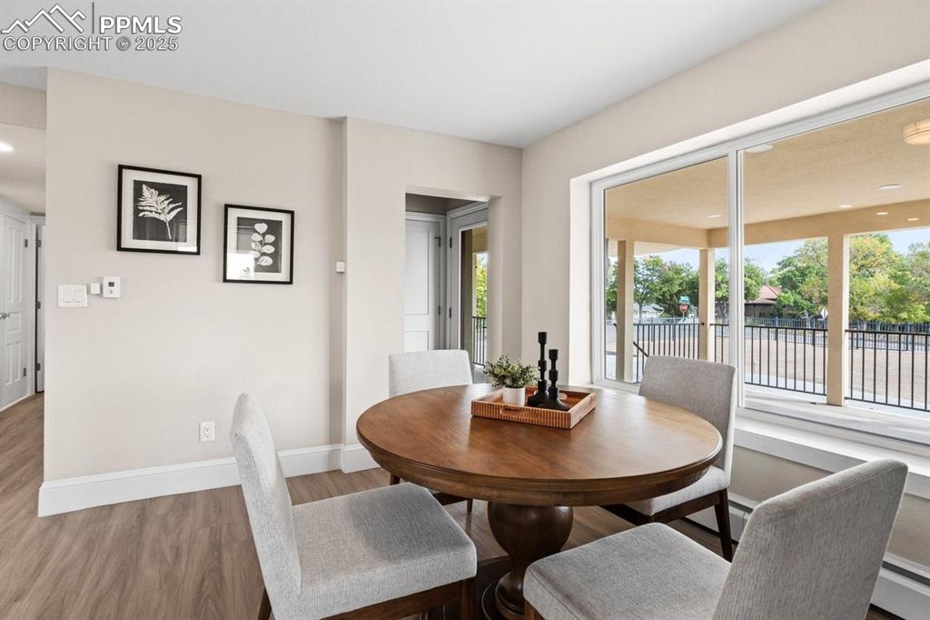 Image 6 of 50: Dining space with wood finished floors, healthy amount of natural light, an