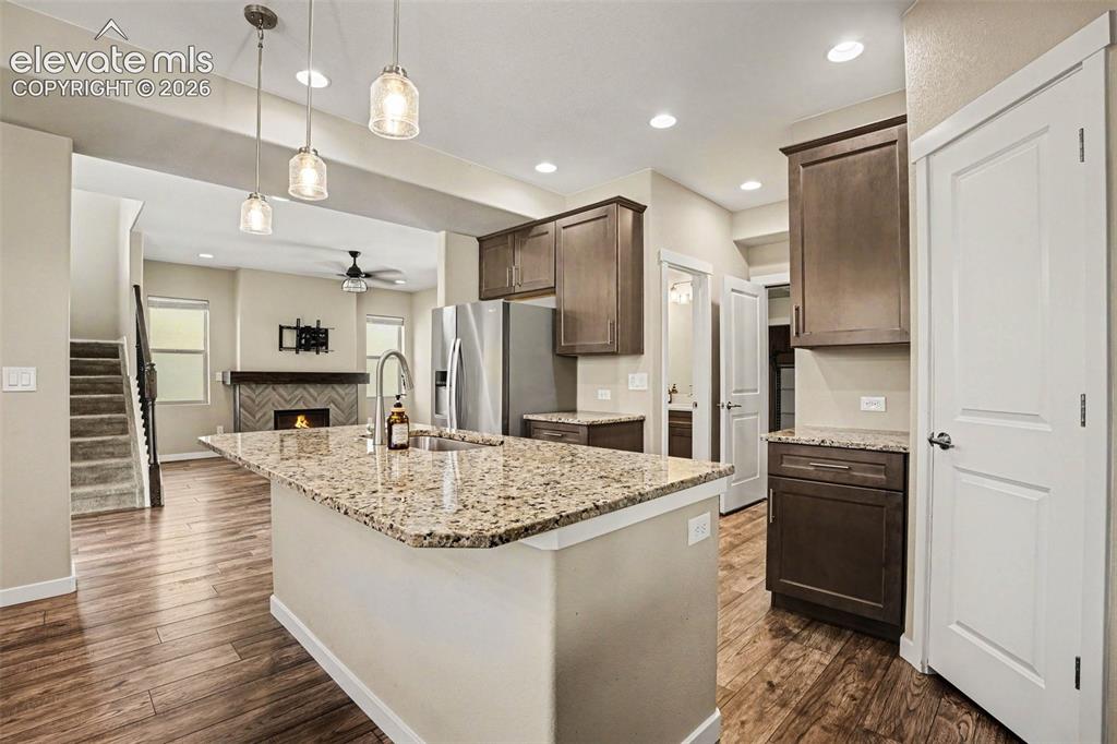 Image 11 of 27: Open-concept living area with wood-finish flooring, recessed lighting, and 