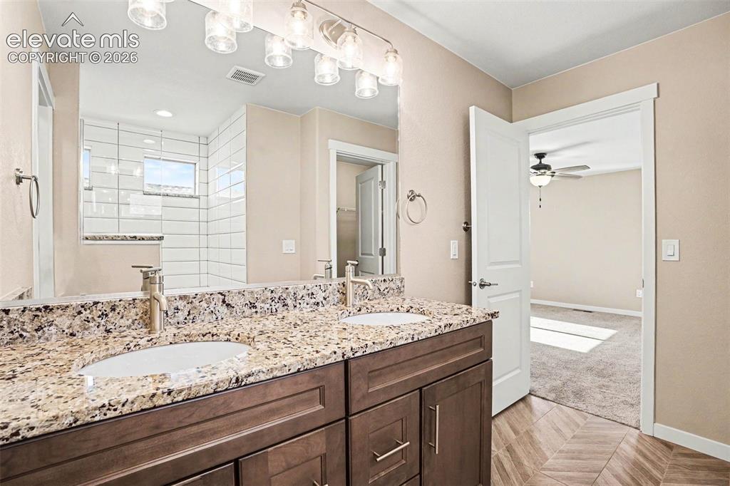 Image 15 of 27: Kitchen featuring a granite-topped island with an undermount sink and a goo