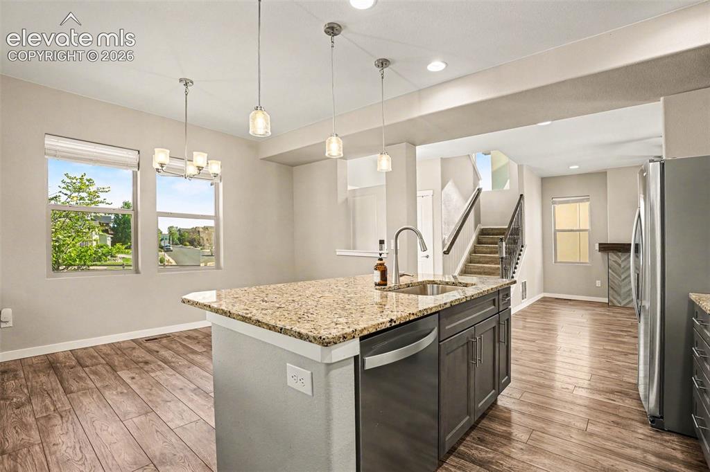 Image 8 of 27: Spacious living area featuring a fireplace with a herringbone-patterned til