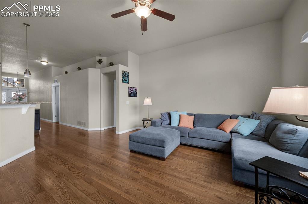 Image 7 of 31: Living area with ceiling fan, oak hardwood flooring