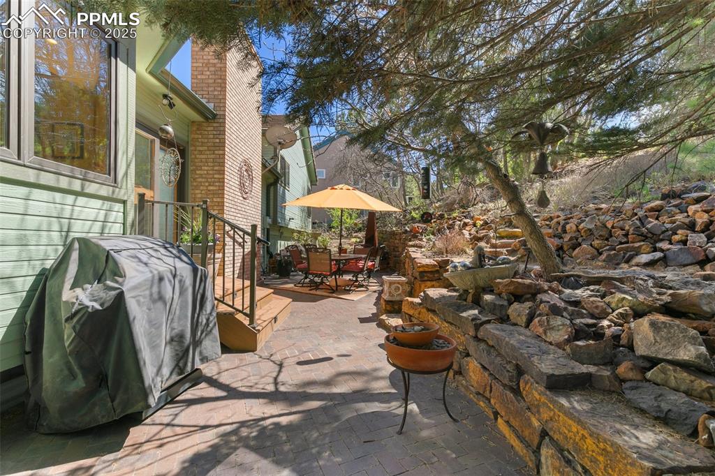 Image 30 of 37: View of patio / terrace with area for grilling and outdoor dining area.