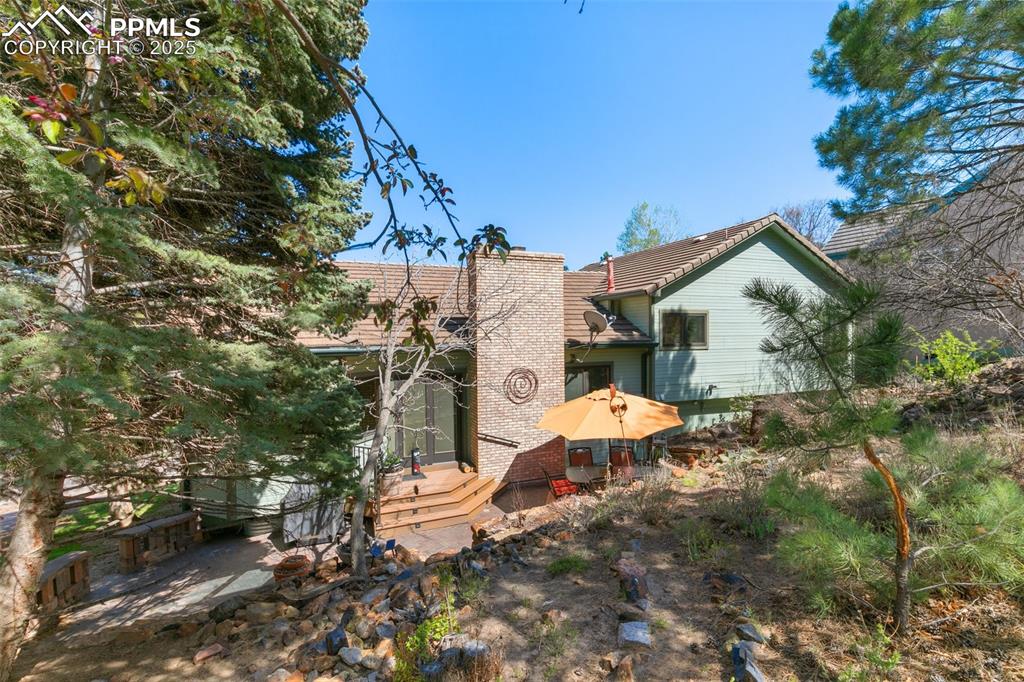 Image 31 of 37: Rear view featuring the treed lot