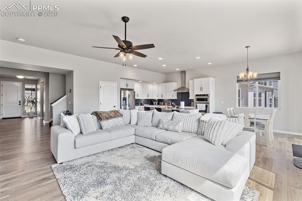 Image 11 of 44: Open-concept living space featuring wood-finish flooring, recessed lighting