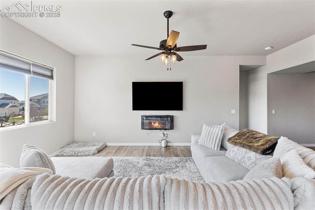 Image 12 of 44: Spacious living area featuring light-toned walls, wood-finish flooring, and