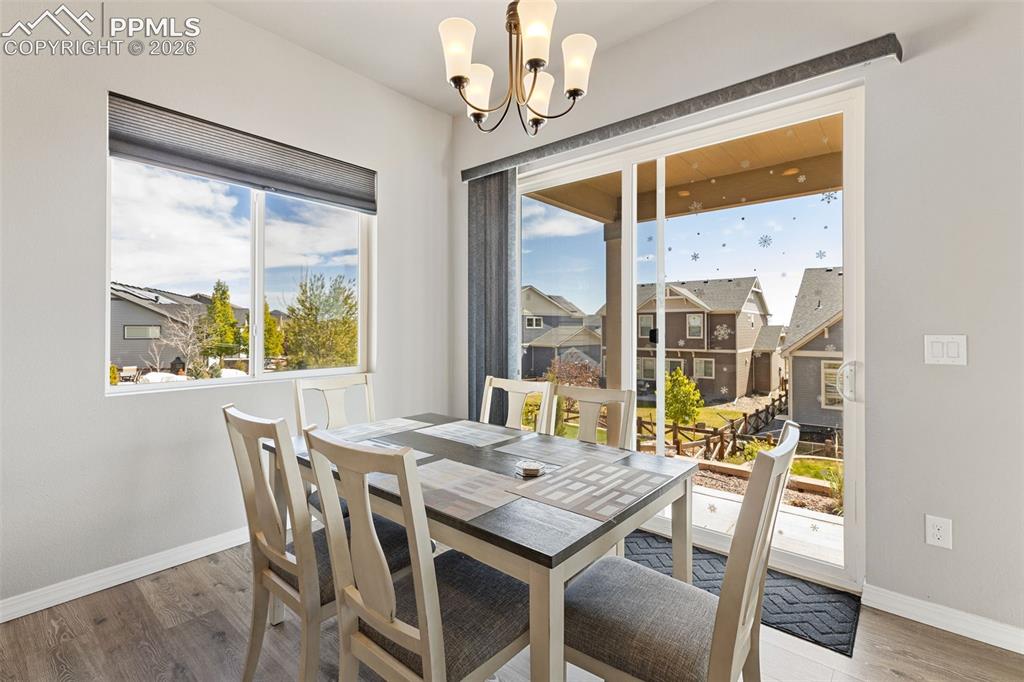 Image 13 of 44: Dining area featuring wood-finish flooring, a contemporary chandelier, a la