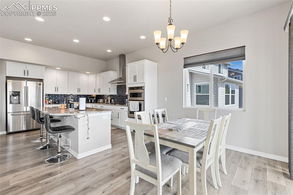 Image 14 of 44: Contemporary kitchen featuring white cabinetry, stainless steel appliances,