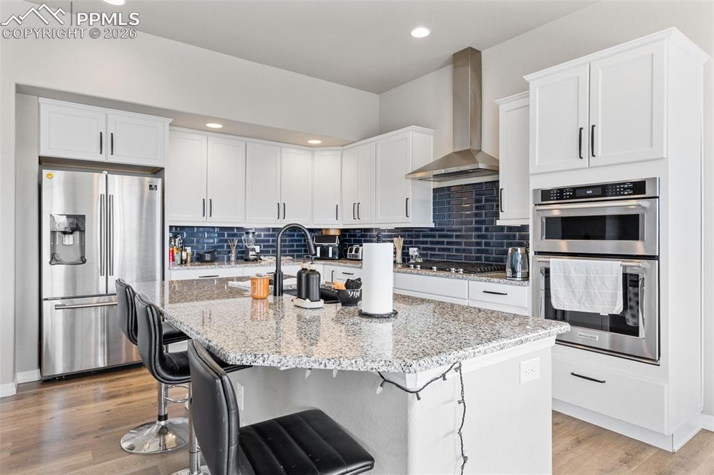 Image 16 of 44: Kitchen featuring an oversized central island with a stone-finish counterto